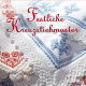 Cover des Buches 'Festliche Kreuzstichmuster' mit rot und blau bestickten weißen Tüchern