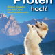 Cover des Buches 'Die Pfoten hoch' mit einem Hund, der Männchen macht und dahinter eine Landschaft mit Holzhäusern und Bergen