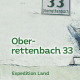 Cover des Buches 'Oberrettenbach' mit einer Mauer, auf der ein Hausnummernschild mit der Zahl dreiundreißig und Schriftzug Oberrettenbach