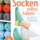 Cover des Buches 'Stylische Socken selbst häkeln' mit verschiedenfarbigen Wollknäuel und bunten gehäkelten Socken