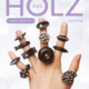 Cover des Buches 'Kreativer Schmuck aus Holz' mit ausgestreckter Hand, darauf verschiedener Schmuck aus Holz