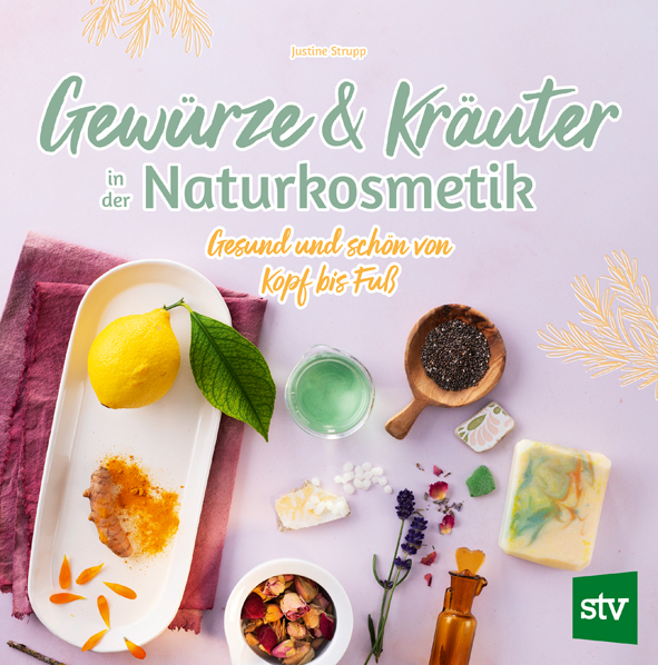 Cover des Buches 'Gewürze & Kräuter in der Naturkosmetik' mit verschiedenen Zutaten und Materialien aufgebreitet, um Naturkosmetik herzustellen