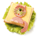 Eine Scheibe Toast mit einem Blatt Käse, darauf eine aus Wurst ausgeschnittene Katze mit Olivenaugen und Schnittlauchschnurrbart