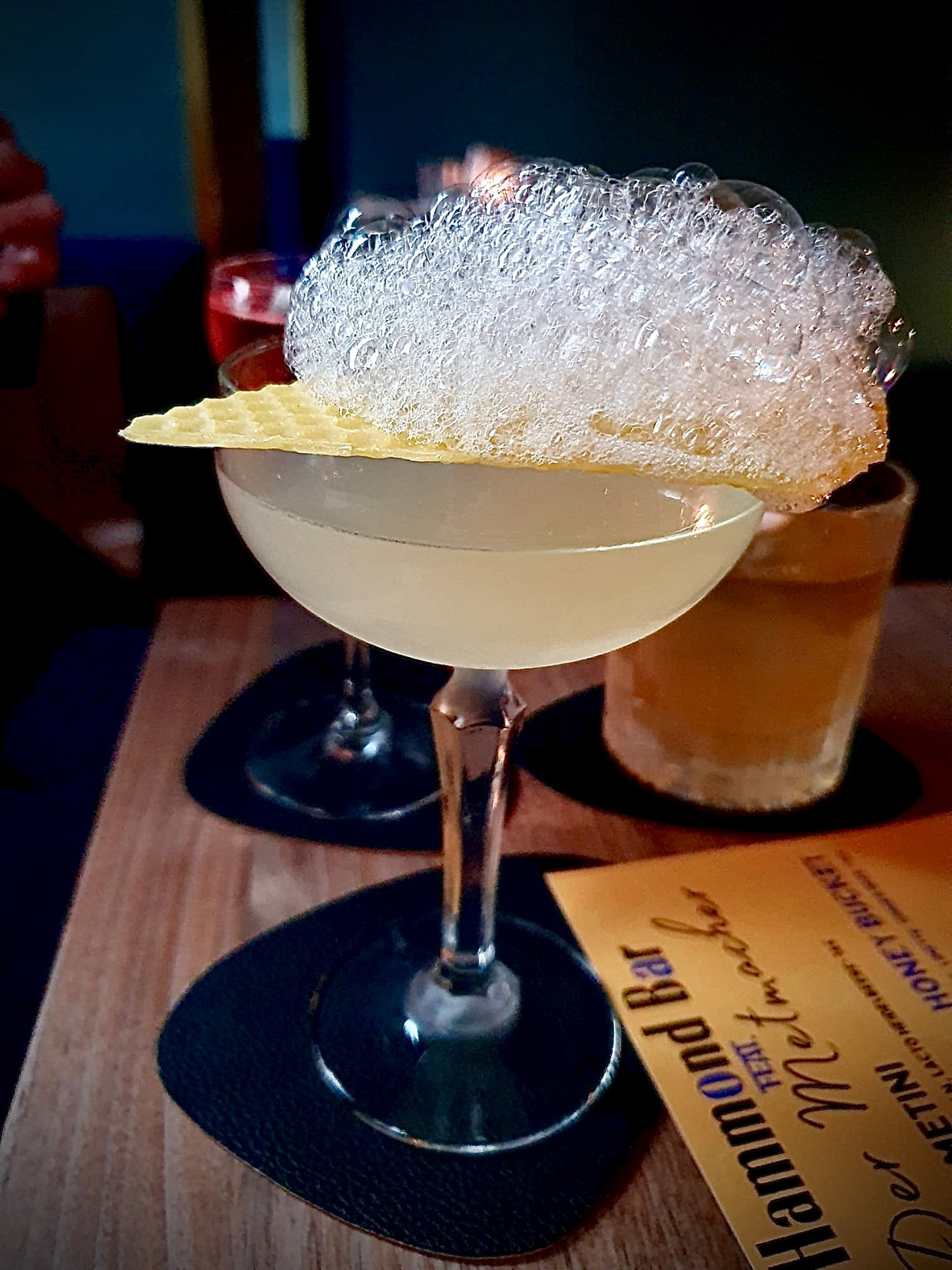 Cocktailglas gefüllt samt Garnierung, das auf einem Tisch steht