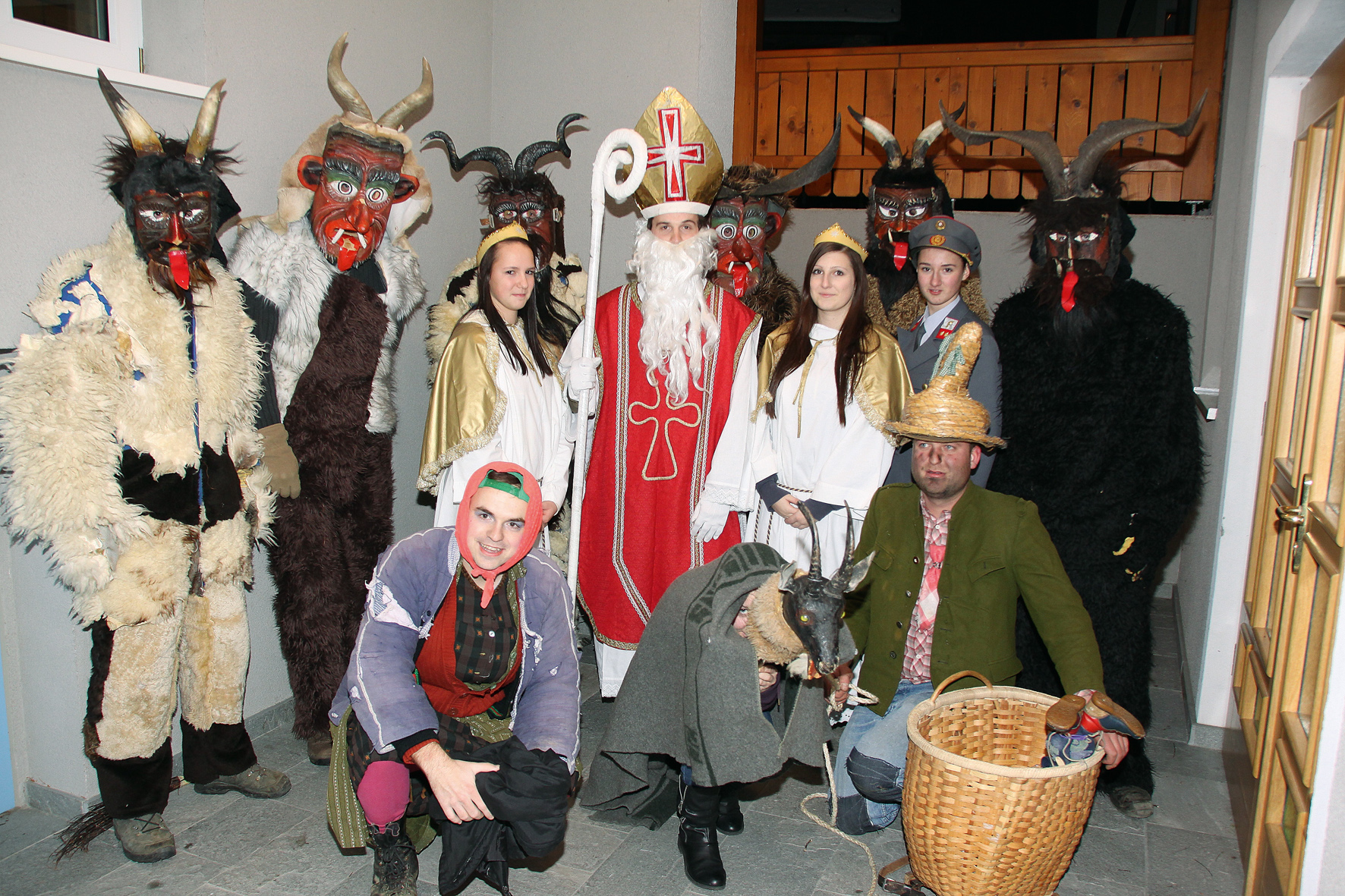 Eine Gruppe von verkleideten Menschen, etwa als Krampusse, Nikolo und Engerl