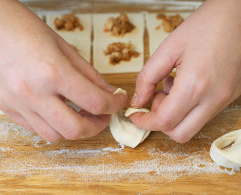 zwei Hände, die gerade ein Tortellini formen