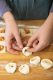 zwei Hände, die die Tortellini-Teigenden festdrücken