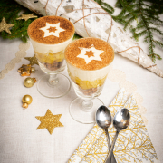 Zwei Glasschalen mit Schichtdessert gefüllt, die weihnachtlich dekoriert sind