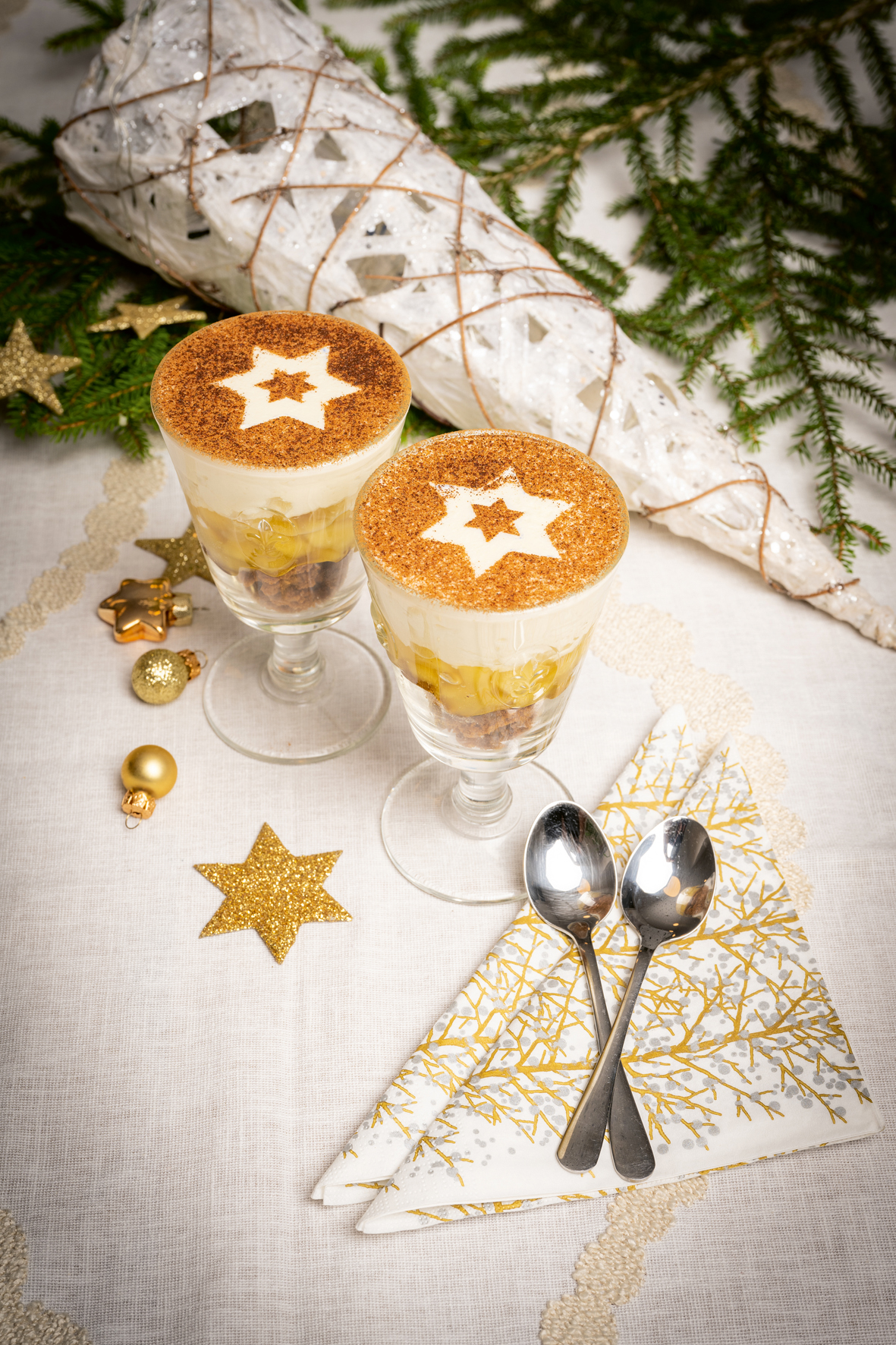 Zwei Glasschalen mit Schichtdessert gefüllt, die weihnachtlich dekoriert sind