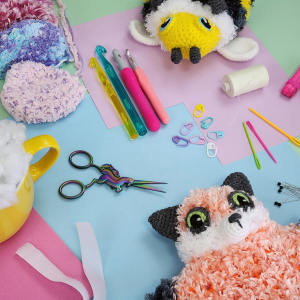 Abbildung zweier gehäkelter Kuscheltiere und Bastelmaterial
