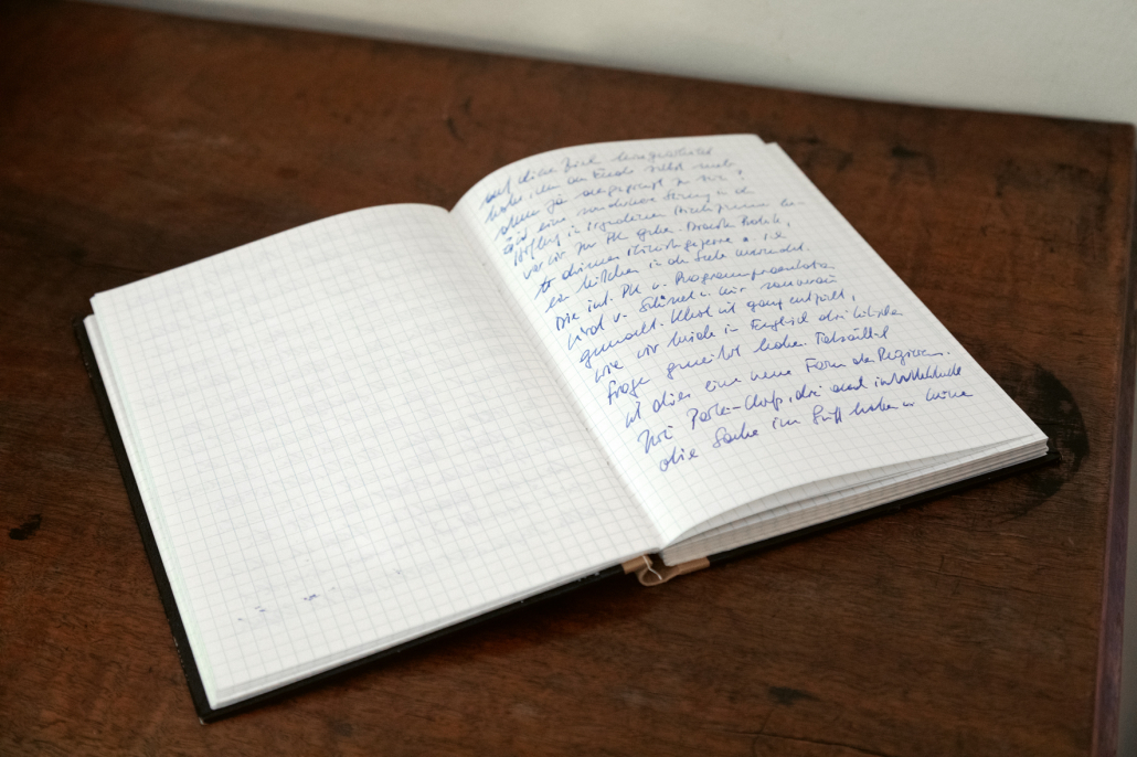 aufgeschlagenes Notizheft, bei dem die rechte Seite handschriftlich beschrieben wurde