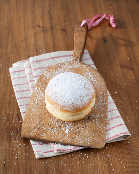 Ein Krapfen auf einem Holzbrett angerichtet