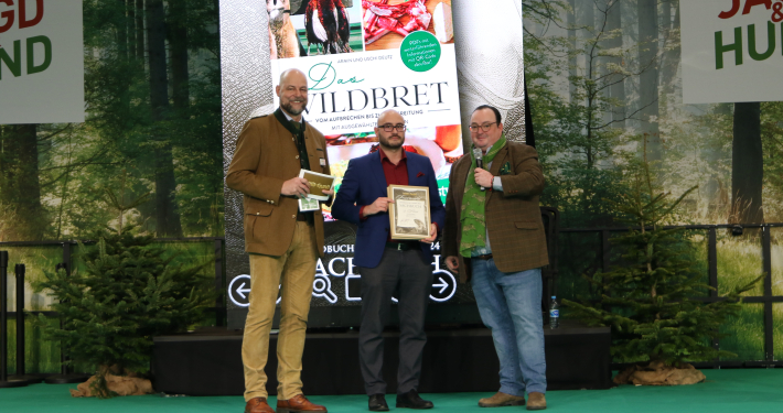Maximilian Dvorak-Stocker bei der Preisverleihung des Jagdbuch des Jahres 2024 mit einer Urkunde für den Titel 'Das Wildbret'