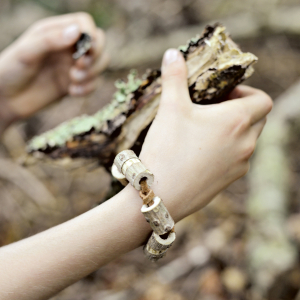 Eine Kinderhand die ein Stück Holz hält