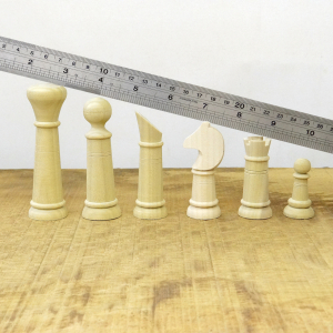 Sech gedrechselte Schachfiguren.