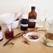 mehrere gefüllte Gefäße, etwa kleine braune Fläschchen mit Alkohol, Glycerin und Gemmo-Mazerat auf einem Tisch