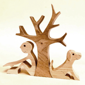Eine Holzfigur von einem Mann und einem Hund die unter einem Baum sitzen