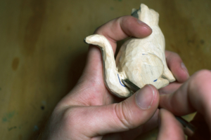 20_Cat_carving_images-Step_12b Eine aus Holz geschnitzte Katze, die gerade mit dem Schnitzwerkzeug bearbeitet wird