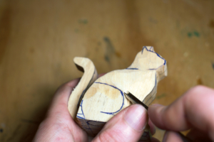 Eine Katze, die aus einem Stück Holz geschnitten wurde und mit einem Schnitzwerkzeug bearbeitet wird Eine Katze, die aus einem Stück Holz geschnitten wurde und mit einem Schnitzwerkzeug bearbeitet wird