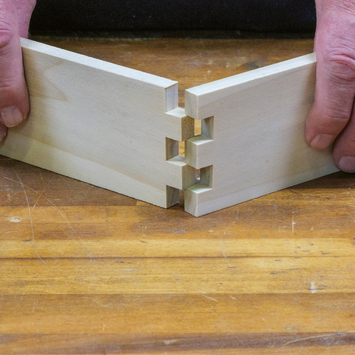 Zwei Holzstücke die ineinander gestecke werden