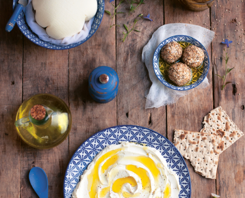Mehrere Schalen stehen auf einem Tisch, gefüllt mit einer Labneh-Kugel, Labneh-Frischkäse und kleinen Labneh-Bällchen