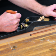 Ein Holzstück wird mit einem Hobel gehobelt