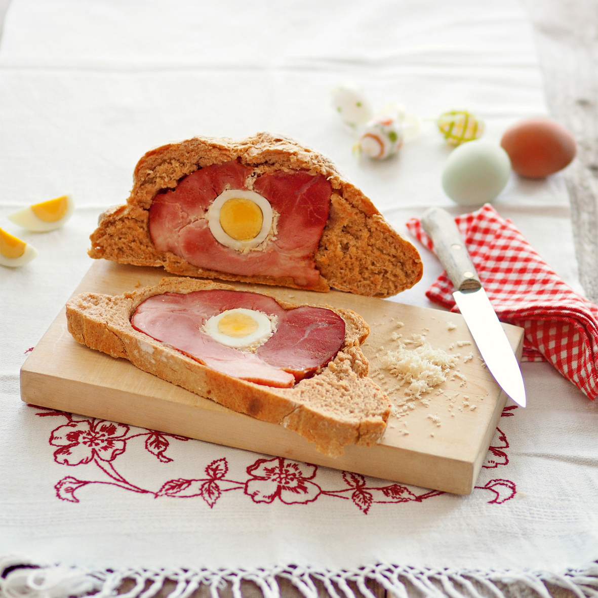 OLYMPUS DIGITAL CAMERA Osterschinken in einem Brotlaib der angeschnitten auf einem Brett liegt