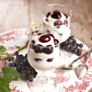 Zwei Dessertgläser gefüllt mit Weincreme, garniert mit Weintrauben