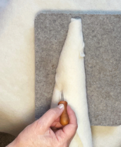 Mit der Filznadel wird entlang des Saumes gefilzt Mit der Filznadel wird entlang des Saumes gefilzt