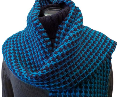 Ein schwarz-blauer Schal, der um den Hals einer Schaufesterpuppe gewickelt ist