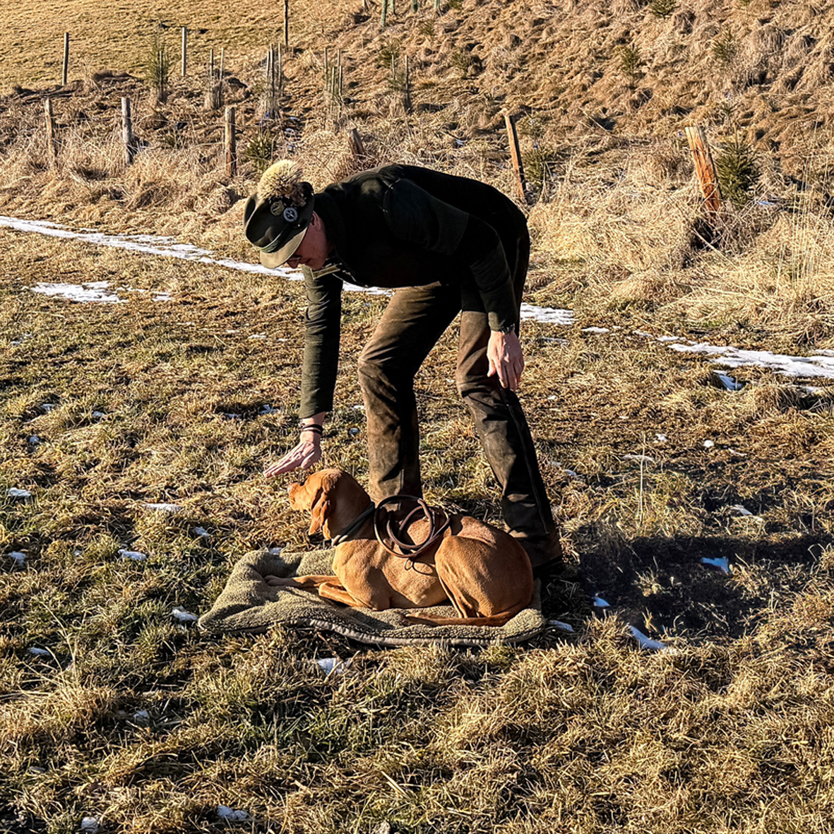 2a20260116_135455752_iOS_neu Ein Hund liegt auf dem Boden, daneben steht ein Jäger
