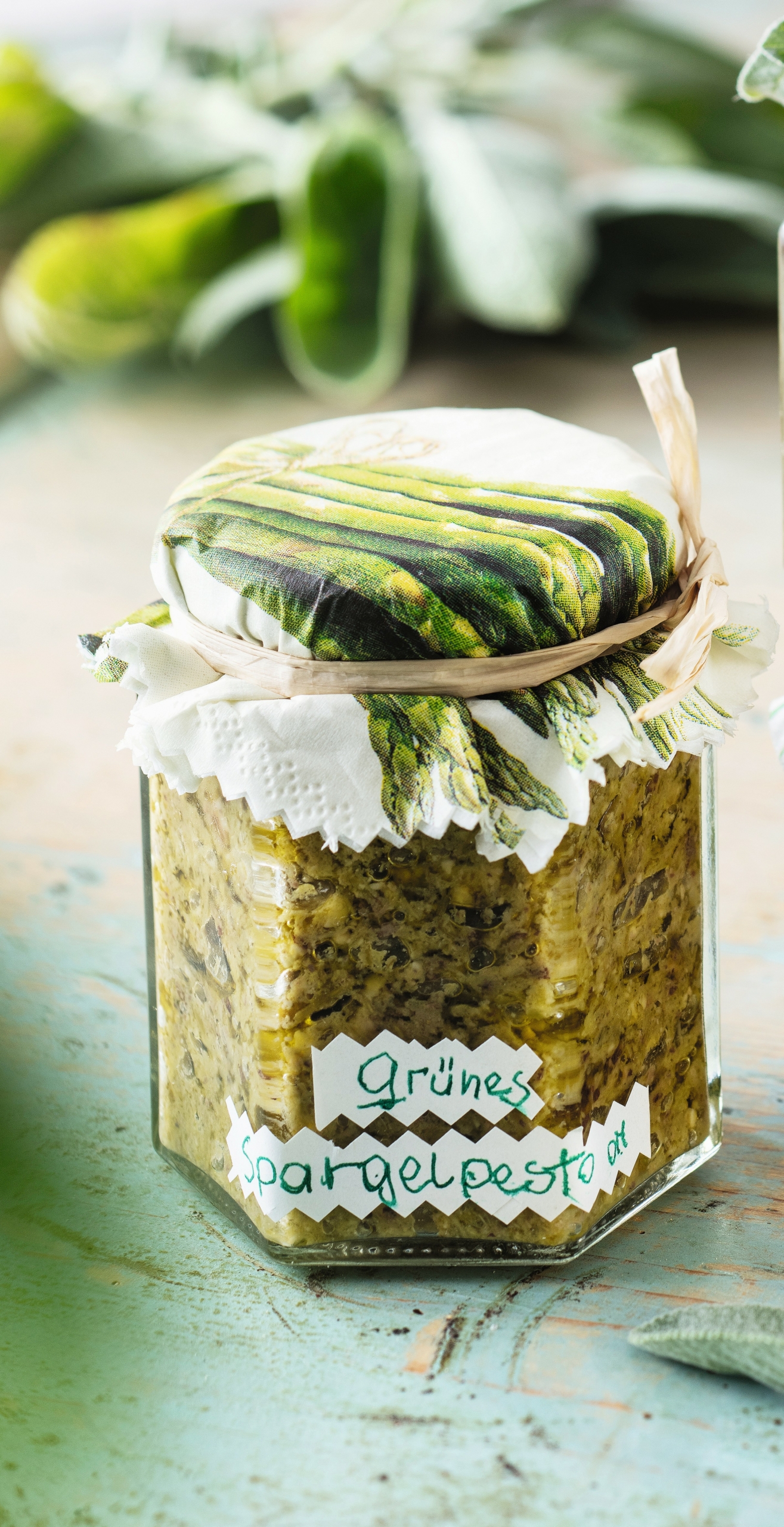Ein durchsichtiges Glas befüllt mit grünem Spargelpesto. Ein durchsichtiges Glas befüllt mit grünem Spargelpesto.