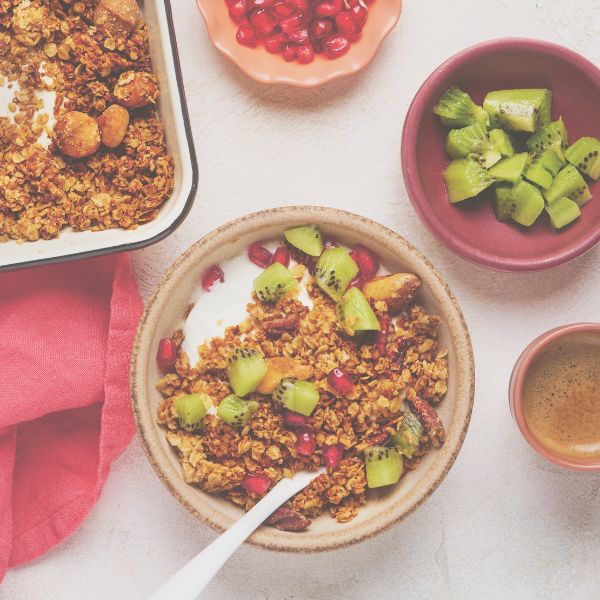 2 mit Müsli und Obst gefüllte Schüsseln und Teller