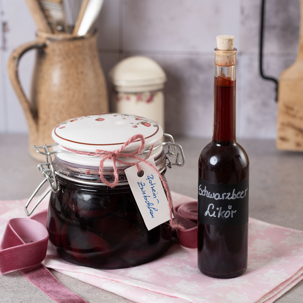 _AH00213 Ein Glas eingemachte Zwetschken und eine Flasche Schwarzbeer Likör