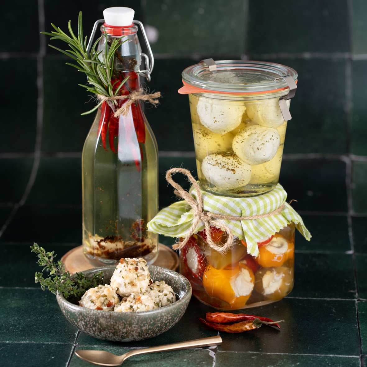 _AH00297 Mehrere Gläser mit eingelegtem Käse und Gemüse sowie eine Flasche mit Chilli-Öl