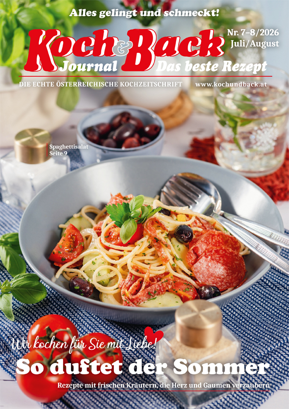 Cover des Koch und Back Journals mit einem mit Spaghetti, Tomaten und Salami gefüllten Teller mit einer Gabel und Löffel, auf einem gedeckten Tisch mit Gläsern und Schüsseln im Hintergrund